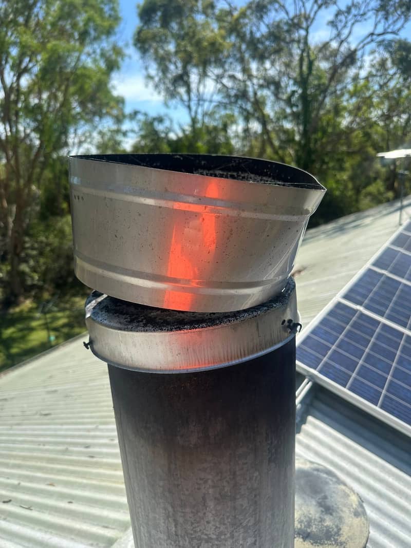 A newly fitted flue cap on a rooftop chimney